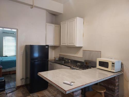 a kitchen with a black refrigerator and a microwave at Bonito Departamento Amueblado y se factura in Guaymas