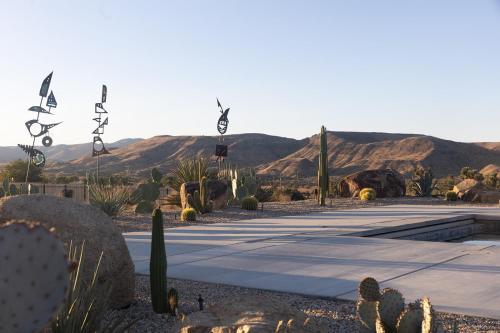 a desert with a lot of cactuses and signs at The Raven By The Cohost Company in Pioneertown