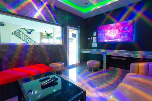 a room with a bar with a couch and a tv at 99 Pool Villa in Jomtien Beach