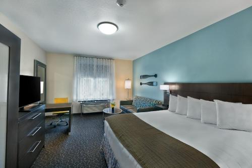 a hotel room with a bed and a flat screen tv at Oxford Suites Bellingham in Bellingham