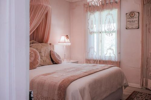 Un dormitorio con una cama grande y una ventana. en Jasmine's Barossa Valley Cottage, en Lyndoch
