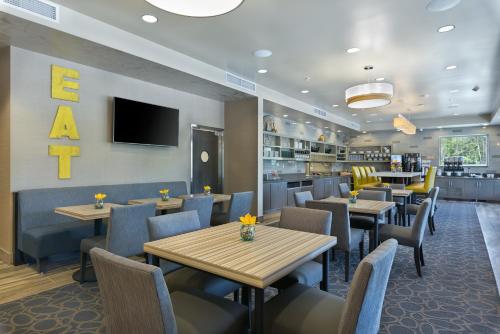 a restaurant with tables and chairs and a tv at Oxford Suites Bellingham in Bellingham