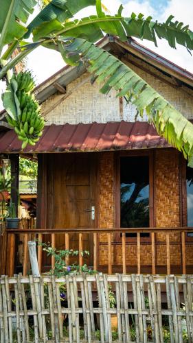 a house with a bunch of bananas hanging from it at Kurni's Cabin in Sapit