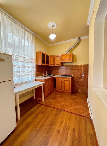 a kitchen with wooden cabinets and a large window at Paloma Bed and Breakfast in Dilijan