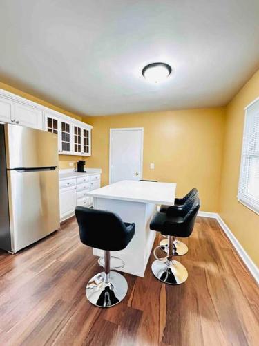 a kitchen with a white counter and two black chairs at Convenient Stay near Chicago Ohare Airport with King Beds and Coffee in Des Plaines