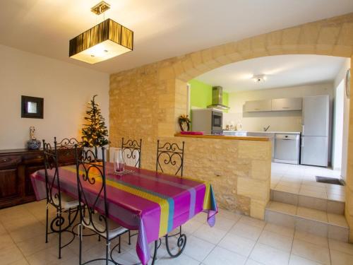 une salle à manger avec une table et une cuisine dans l'établissement Maison au calme avec jardin, proche de Sarlat - Idéale pour familles et activités en plein air. - FR-1-616-295, à Carlux
