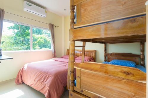 a bedroom with a wooden bunk bed and a window at 99 Pool Villa in Jomtien Beach