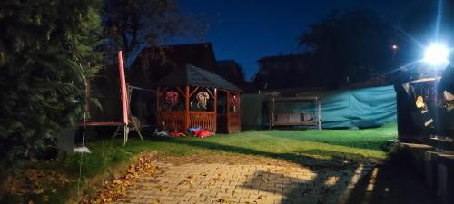 a house with a gate in the yard at night at Chata u kolára in Malatiná