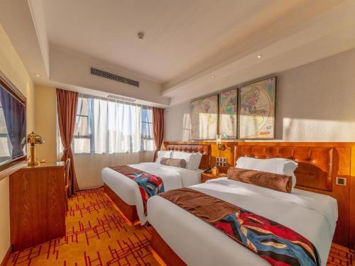 a hotel room with two beds and a window at James Joyce Coffetel Kunming Railway Station Huancheng Nan Road Metro Station in Kunming