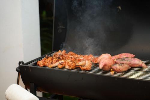 a bunch of meat and vegetables cooking on a grill at Amaya Kampot Homestays in Kampot