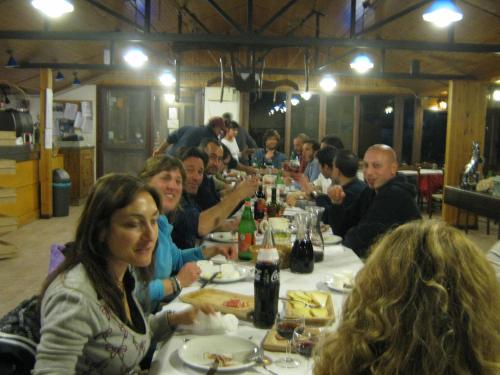 a group of people sitting at a table eating at Agriturismo Maneggio Vallecupa in Pescasseroli