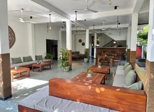 a living room with couches and tables in a building at Drifter - Rooms & Food in Midigama