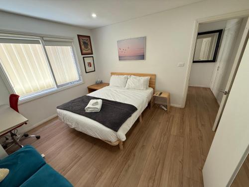 a bedroom with a large bed and wooden floors at Private 1 bedroom apartment near beach and shops in Sydney