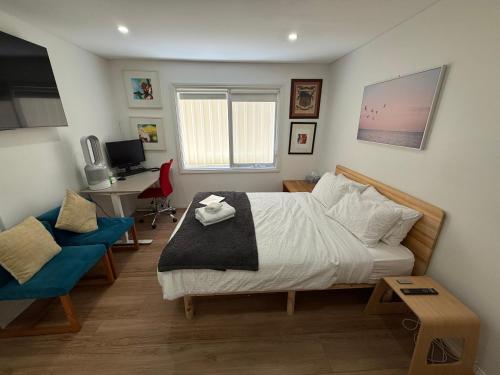 a bedroom with a bed and a desk and a chair at Private 1 bedroom apartment near beach and shops in Sydney