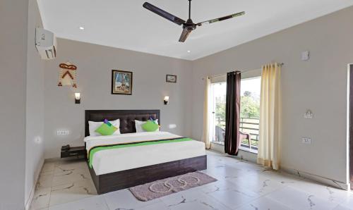 una camera con un grande letto e un ventilatore a soffitto di Corbett The Serene By Sukhmani Resorts a Ramnagar