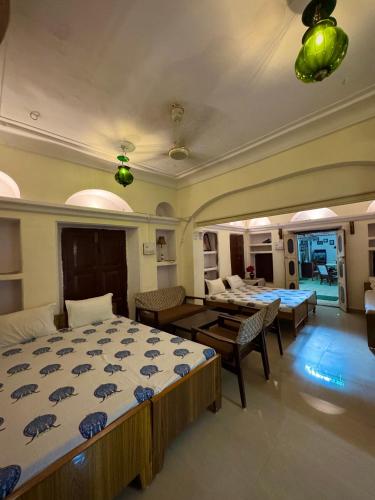 ein Schlafzimmer mit zwei Betten und ein Wohnzimmer in der Unterkunft Natraj Guest House in Ajmer
