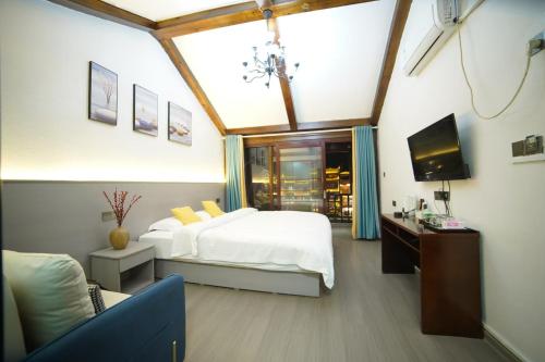 a bedroom with a bed and a tv in a room at Fenghuang Ancient Town Lazy Cat Riverside Inn in Fenghuang