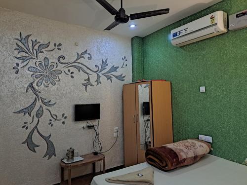 a room with a wall with a flower painted on it at Banolata Lakeside Homestay by StayApart in Damanpur