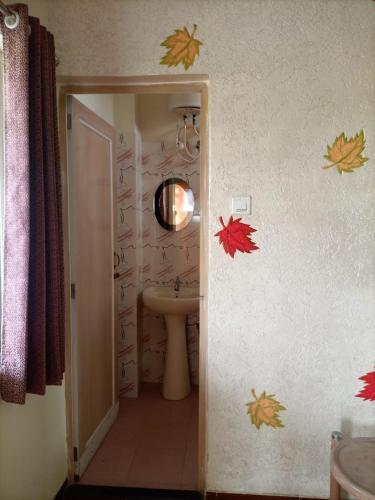 a bathroom with a sink and autumn leaves on the wall at Banolata Lakeside Homestay by StayApart in Damanpur