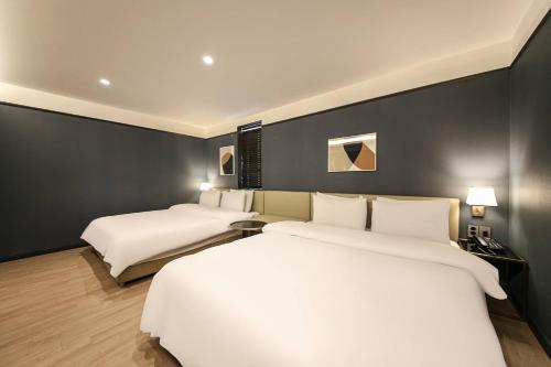 two beds in a room with black walls at Browndot Hotel Deokjin in Jeonju