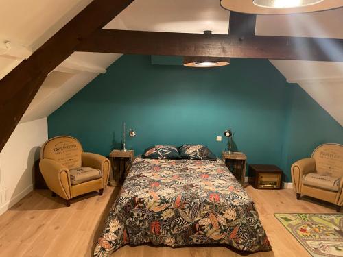 une chambre avec un lit et deux chaises dans l'établissement La Maison Vintage à Montreuil sur mer 3 Chambres - Jardin - 6 personnes - Wifi, à Neuville-sous-Montreuil
