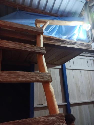 a wooden ladder in a room with a roof at CABAÑA REFUGIO Rodeada de naturaleza y espectacular vista al embalse del Guavio in Las Lagunas