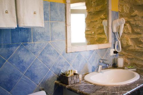 a bathroom with a sink and a stone wall at Casale La Macina - Hotel, Scopello in Scopello