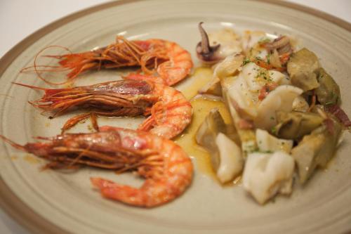a plate of food with shrimp and vegetables on it at Hotel & Spa Can Josep in Bot