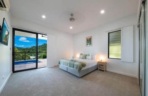 Un dormitorio con una cama y vistas a una piscina. en Airlie Nights, en Airlie Beach
