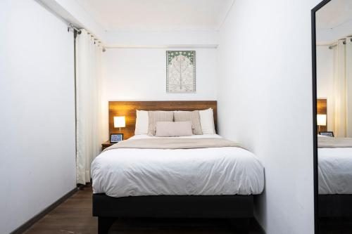 a bedroom with a large bed and a mirror at Town Center Apartments in Urubamba