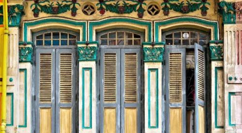 a building with two doors and a bunch of windows at Darlene Hotel in Singapore