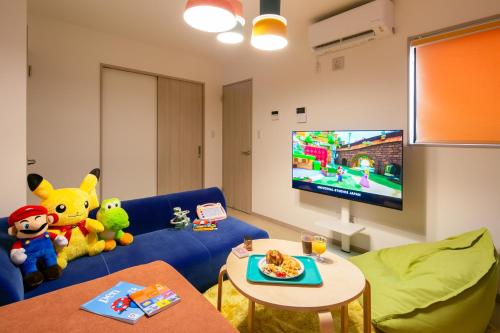 a living room with stuffed animals sitting on a blue couch at M&P Osaka Hotel in Osaka