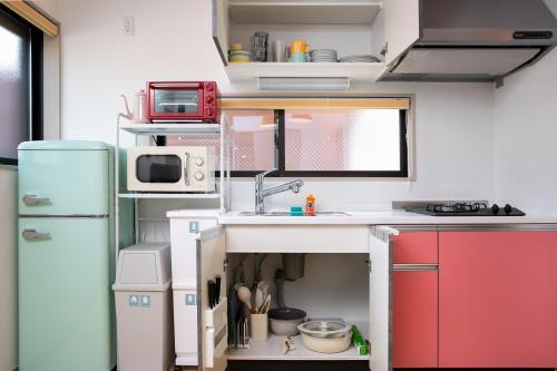 a small kitchen with a sink and a refrigerator at M&P Osaka Hotel in Osaka