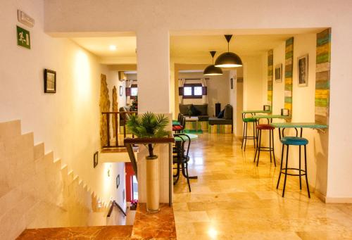 a dining room with tables and stools in a room at Hotel Posada de las Cuevas in Arcos de la Frontera