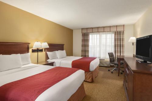 a hotel room with two beds and a flat screen tv at Country Inn & Suites by Radisson, Ames, IA in Ames