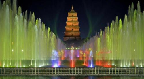a water fountain with a tower in the background at GreenTree Inn Xi'an Yanta District Dayanta Furongyuan Hotel in Xi'an