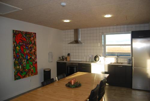 a kitchen with a wooden table and a refrigerator at Rind B&B in Herning