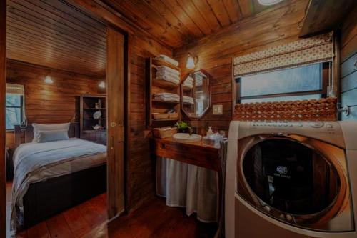 a small room with a bed and a washing machine at Nasu Country Cottage in Nasu-yumoto