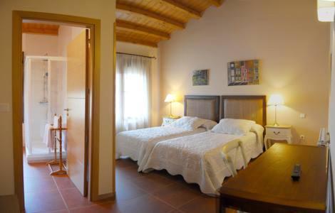 a bedroom with a large bed and a window at Hotel rural Los Manzanos in Rascafría