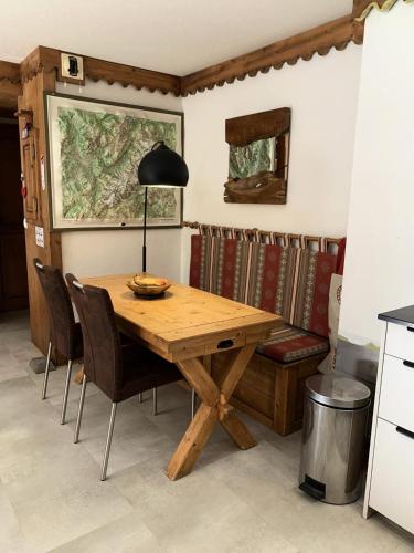 une table à manger avec des chaises et une lampe dans l'établissement Résidence La Ginabelle - maeva Home - Appartement 3 pièces 6 personnes avec parking - Prestige MAE-8604, à Chamonix-Mont-Blanc