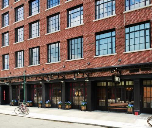a large red brick building with windows on a street at The Ludlow Hotel in New York