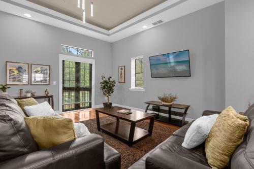 a living room with a couch and a table at 4BR Disney Family Townhouse Resort in Orlando - with Resort Pool, Gym, Games, & Jacuzzi in Orlando