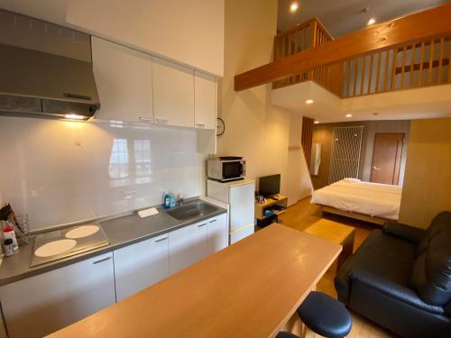 Una cocina con fregadero y una cama en una habitación. en Snowbird, en Kutchan