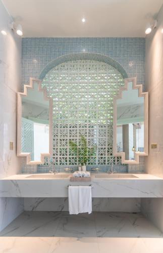 a bathroom with a large mirror and a sink at Malahini Kuda Bandos Resort in North Male Atoll