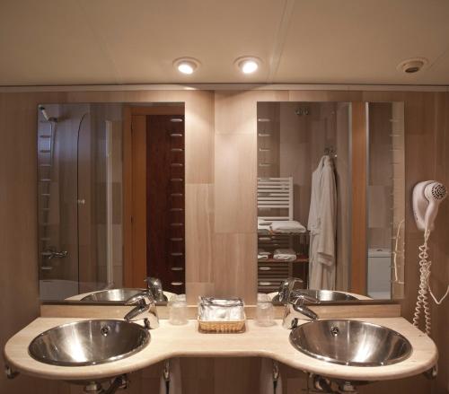 a bathroom with two sinks and a large mirror at Hotel & Spa Can Josep in Bot