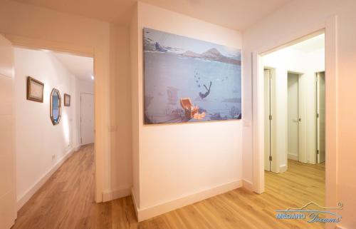 a hallway with a large painting on the wall at Médano Dreams in El Médano