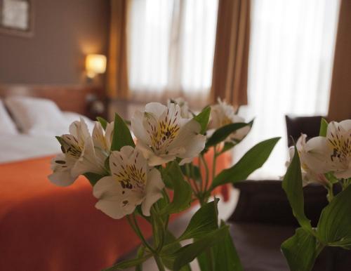 a vase of white flowers on a table in a hotel room at Hotel & Spa Can Josep in Bot