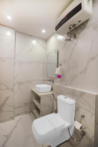 a white bathroom with a toilet and a sink at HOTEL SKY VIEW - Zirakpur, Chandigarh in Zirakpur
