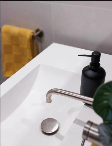 a bathroom sink with aaucet and a soap dispenser at Lakeside Luxe, Free parking, AIS, Spa, Gym, Sauna and Pool in Belconnen