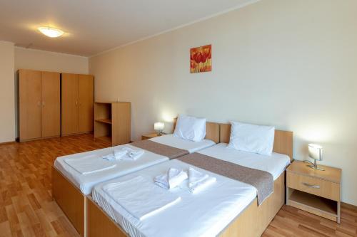 a bedroom with a large bed with white sheets at Midia Holiday Apartments in Aheloy